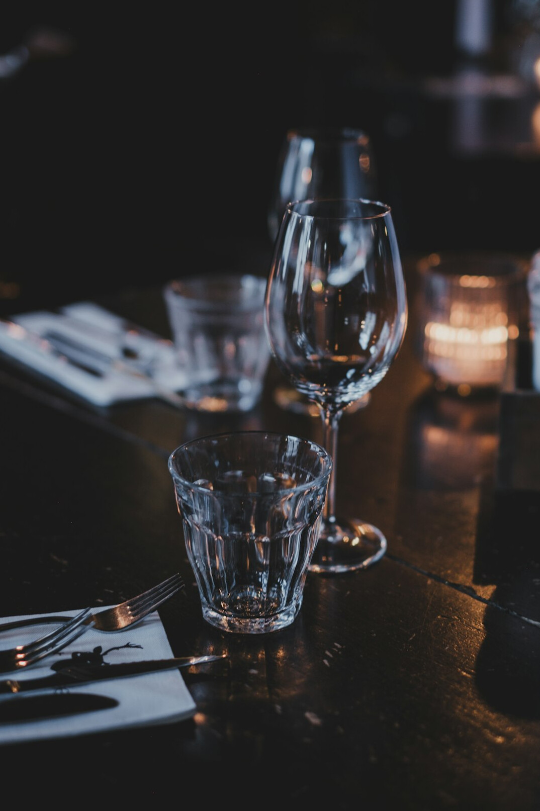 Open mystery novel book with a pair of glasses on a dark table
