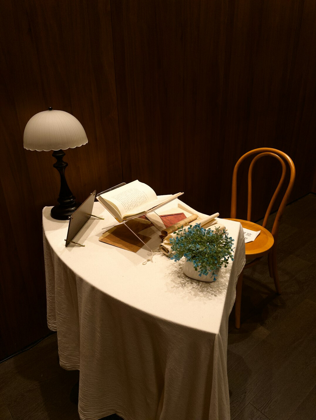 Open books and reading glasses on a wooden library table
